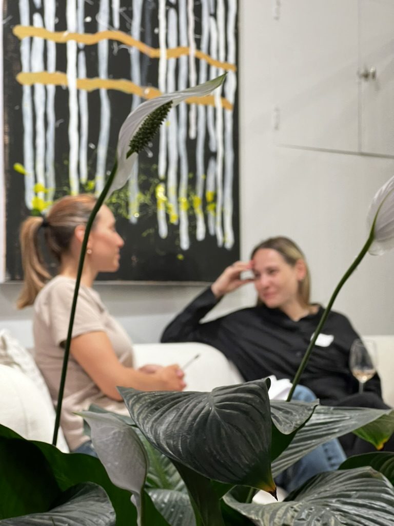 Two women talking on a sofa during an evening session